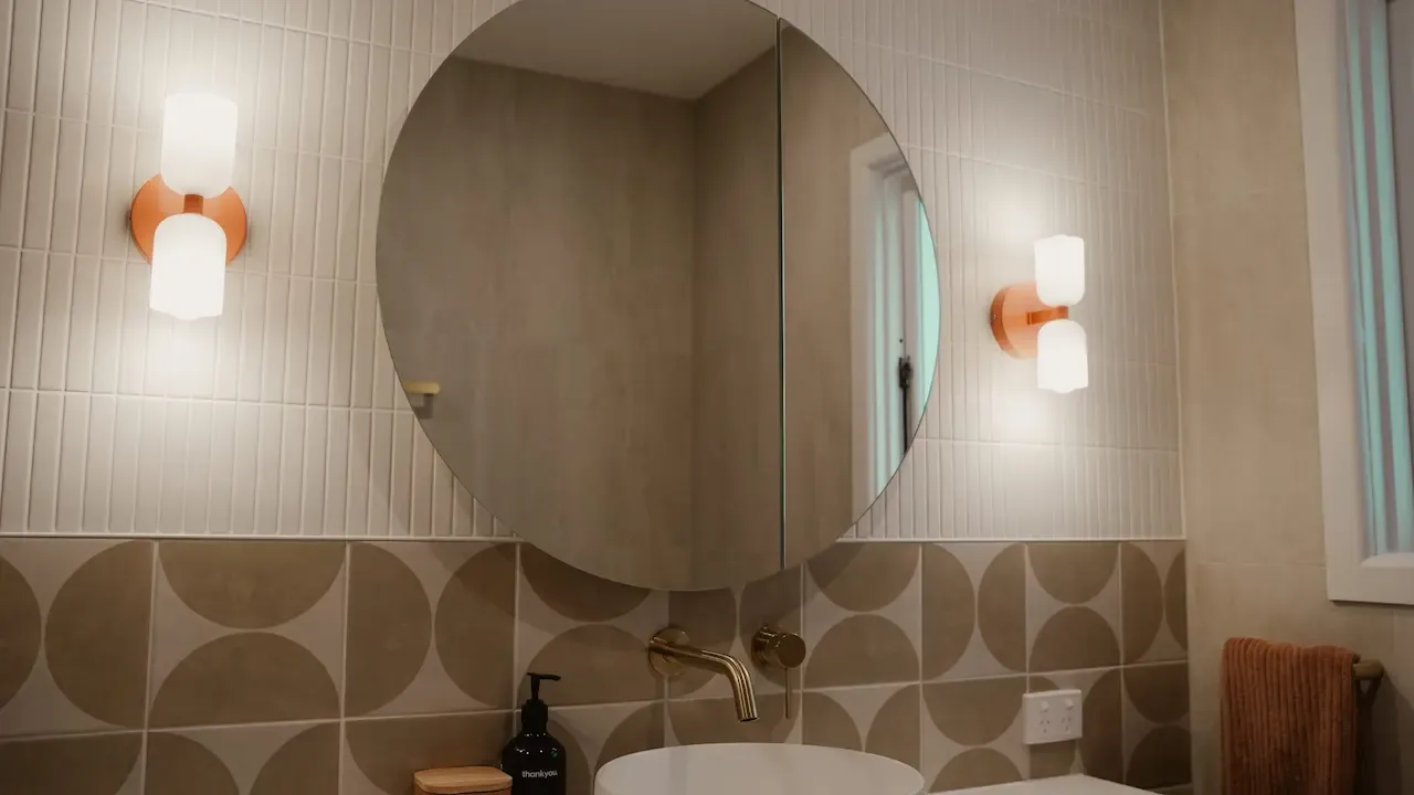 Round mirror above a timber vanity