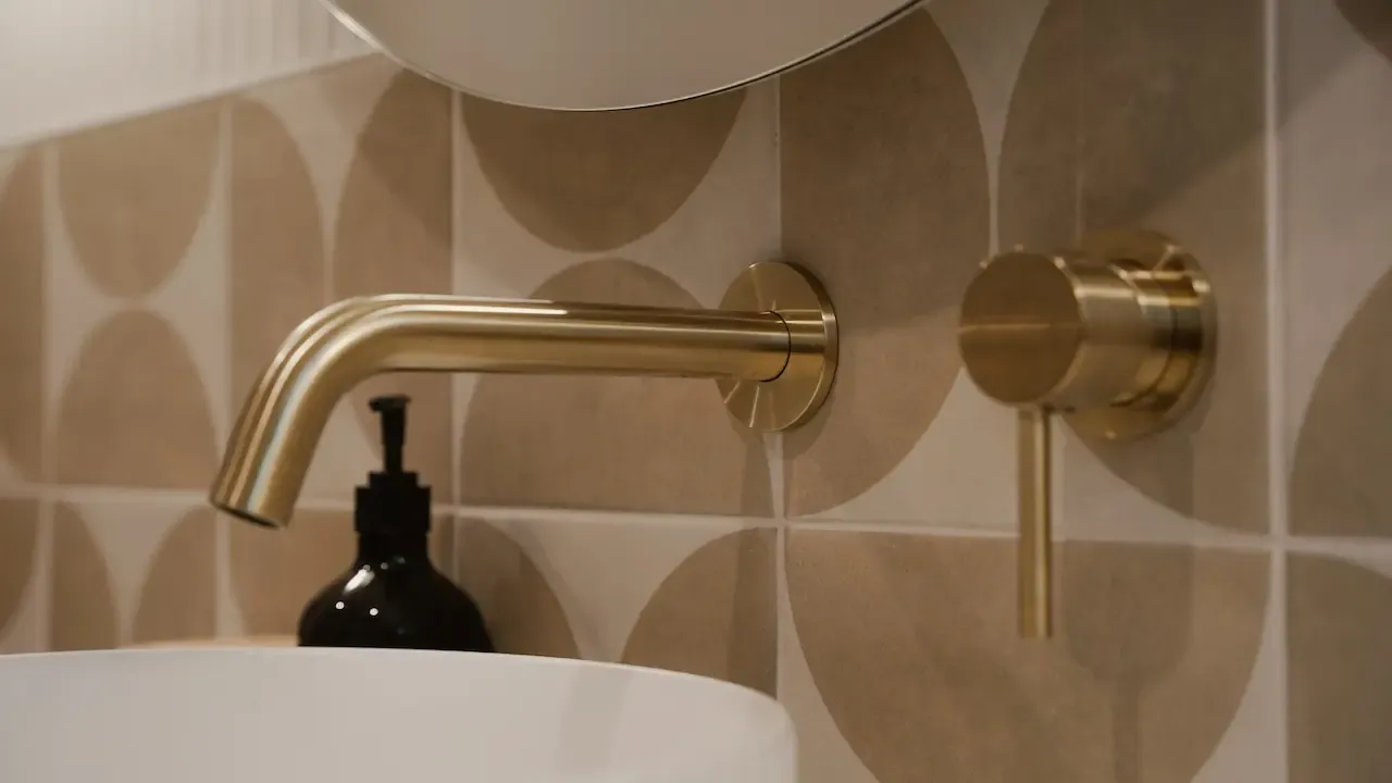 Brass tapware against patterned tile