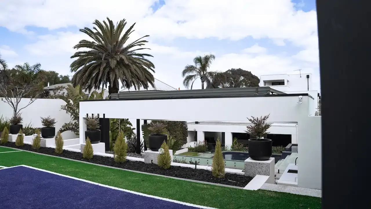 Full view of pool house with main house in the background.