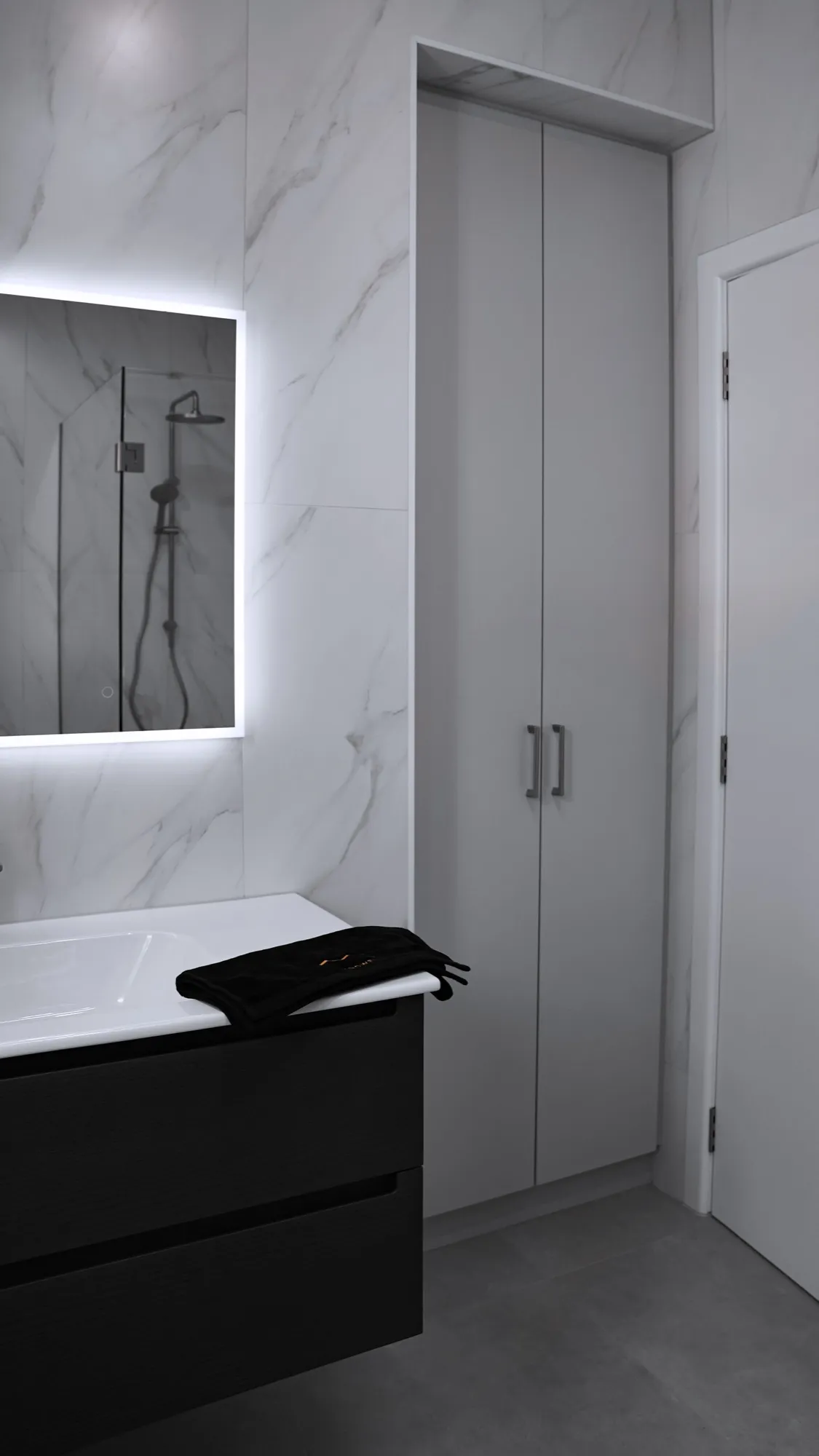 Bathroom with marble-look tiles running floor to ceiling