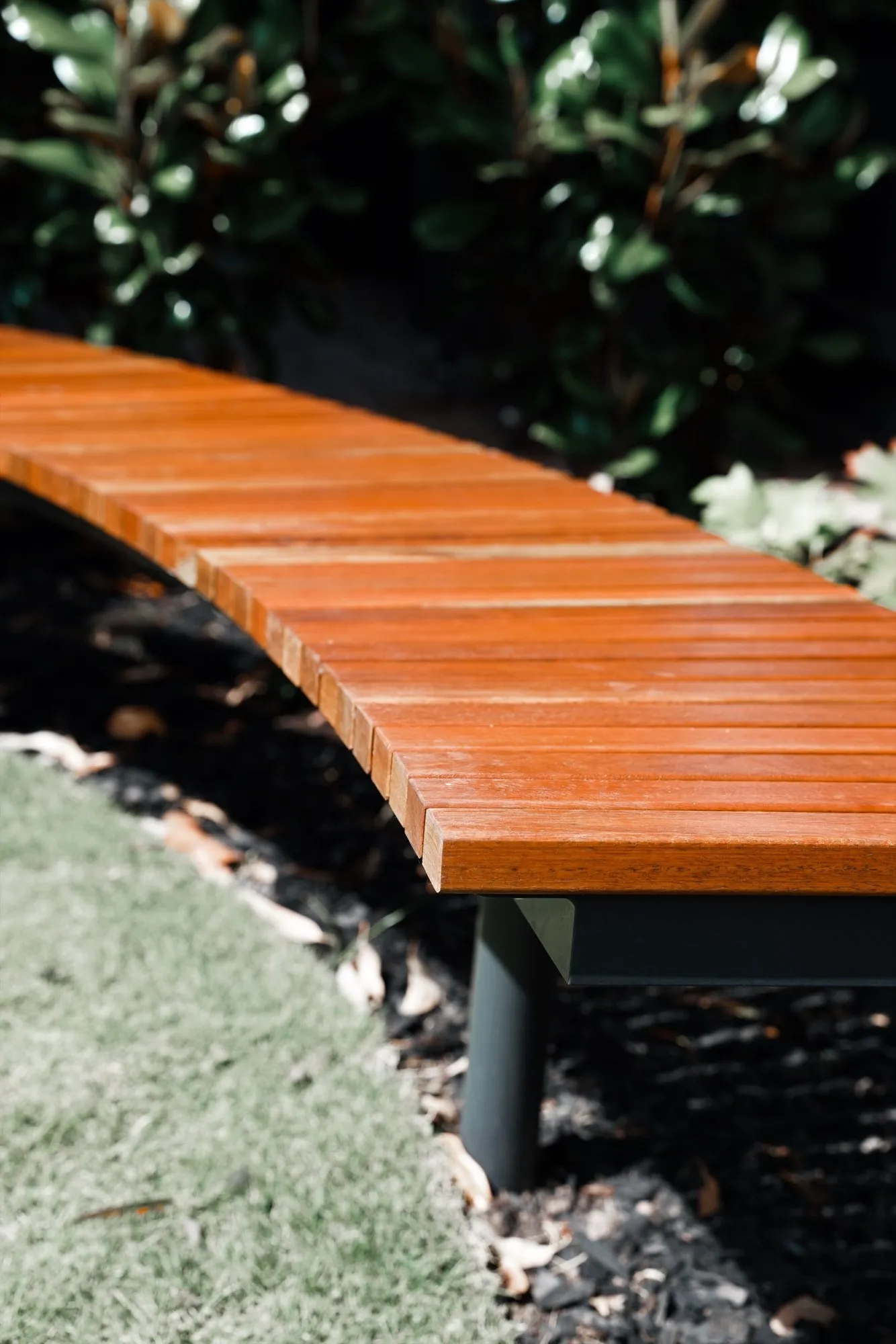 Curved timber bench in a finished garden