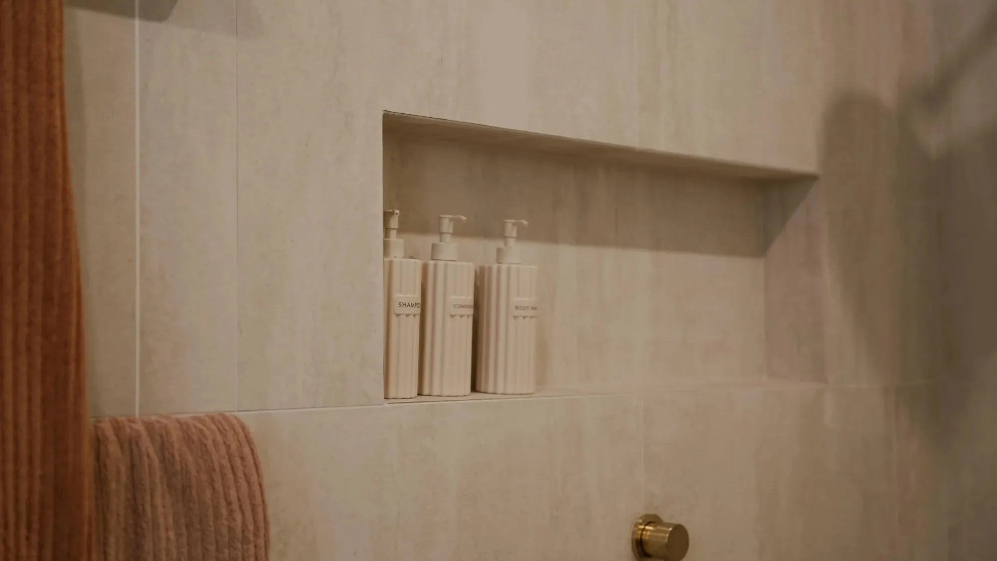 Tiled shower niche with a stone shelf